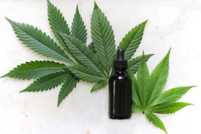 a dropper bottle and marijuana leaves